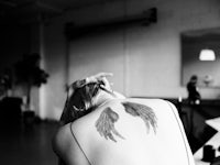 a black and white photo of a woman with wings tattooed on her back