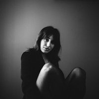 a black and white photo of a woman posing in a dark room