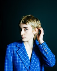 a young woman in a blue suit posing for a photo