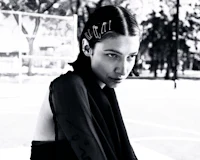 a black and white photo of a woman sitting on a basketball court