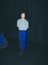 a man in blue pants standing in a dark room