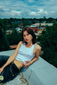 a woman sitting on top of a building