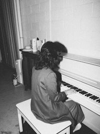 a woman sitting at a piano in a room