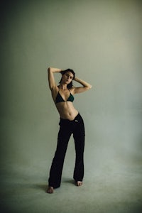 a woman in a green bikini posing in a studio