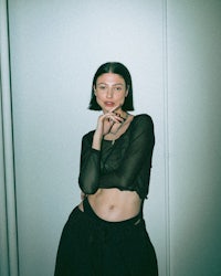 a woman posing for a photo in a black top and skirt