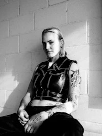 a black and white photo of a woman with tattoos