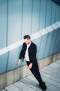 a man leaning against a wall