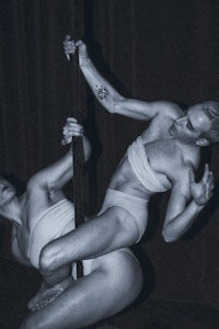 two men performing acrobatics on poles