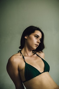 a woman in a green bikini posing