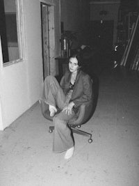 a woman sitting on a chair in an empty room