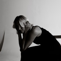 a black and white photo of a woman in a black dress