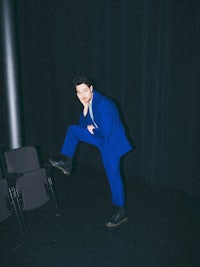 a man in a blue suit is posing for a picture