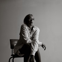 a black and white photo of a woman sitting on a chair