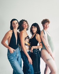 a group of women with tattoos posing for a photo