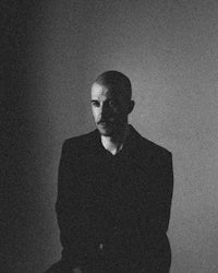 a black and white photo of a man sitting on a chair