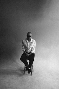 a black and white photo of a man sitting on a chair
