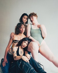 a group of women with tattoos posing for a photo