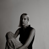 a black and white photo of a woman sitting on the floor