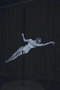a black and white photo of a pole dancer